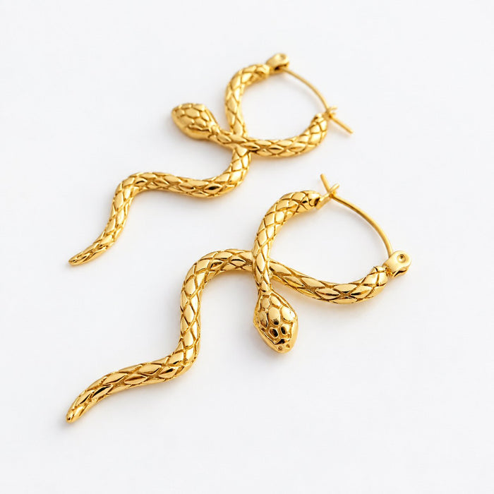 A pair of gold snake-shaped hoop earrings with textured scales and loop backs, displayed on a clean white background.